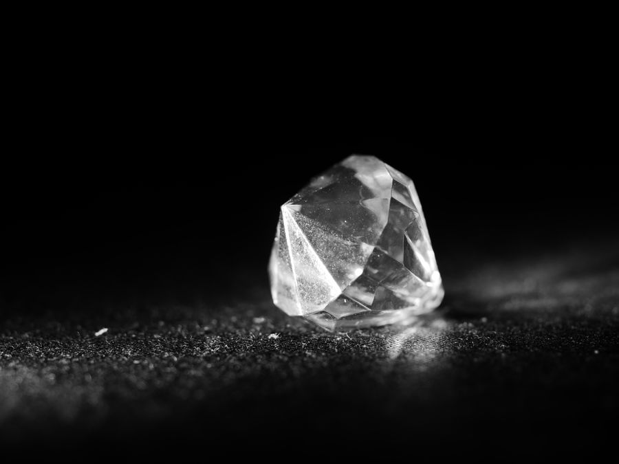 A raw crystal catching light on a dark surface
