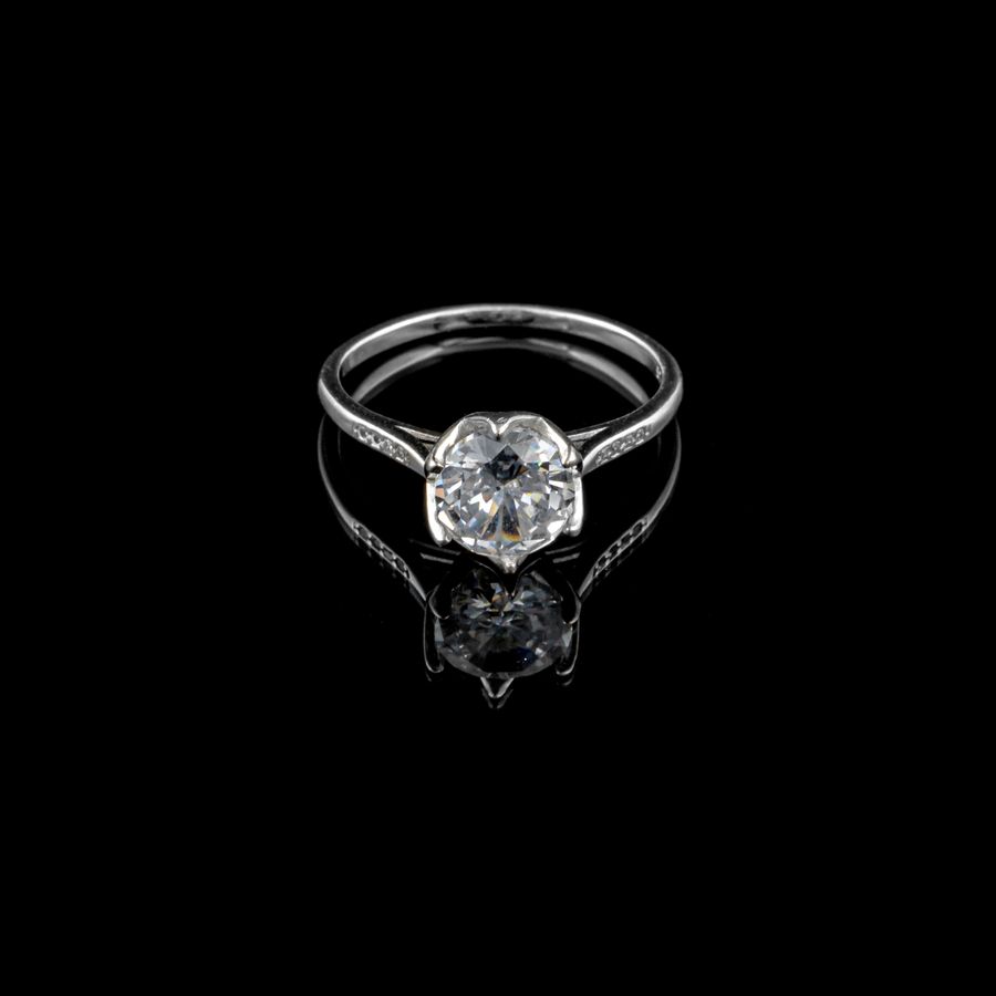 A solitaire diamond ring on a black background