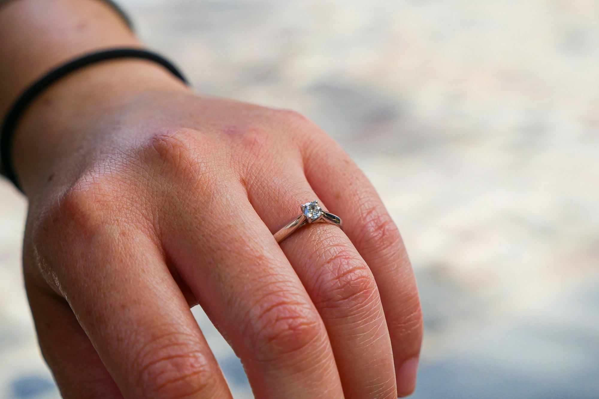 Close-up of a diamond engagement ring worn on a hand